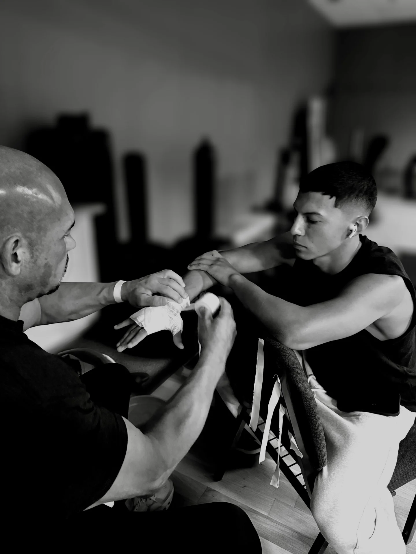 A coach carefully wrapping a fighter’s hands