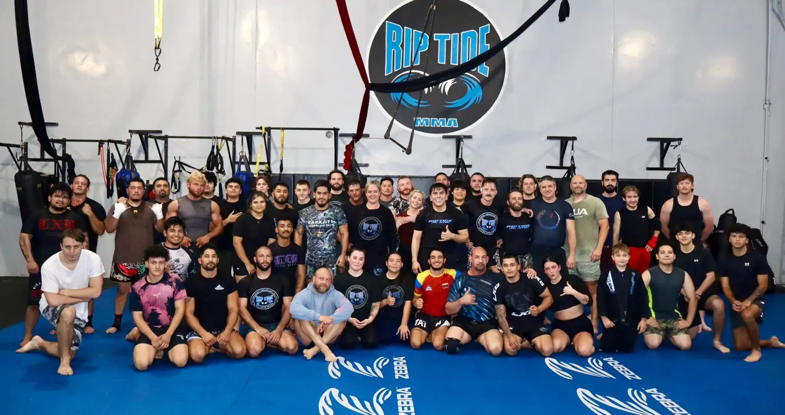 Riptide students gathered across the blue training floor beneath the academy’s wave logo